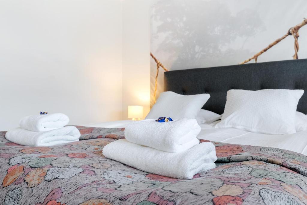 two stacks of towels sitting on top of a bed at Aurora Atelier in Rovaniemi