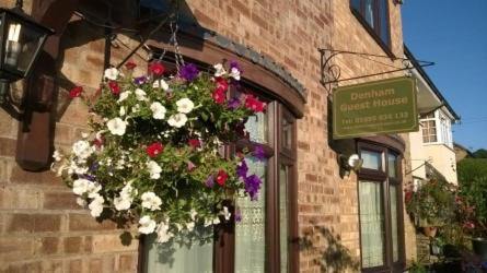 a bunch of flowers hanging on the side of a building at Denham Guest House in Denham