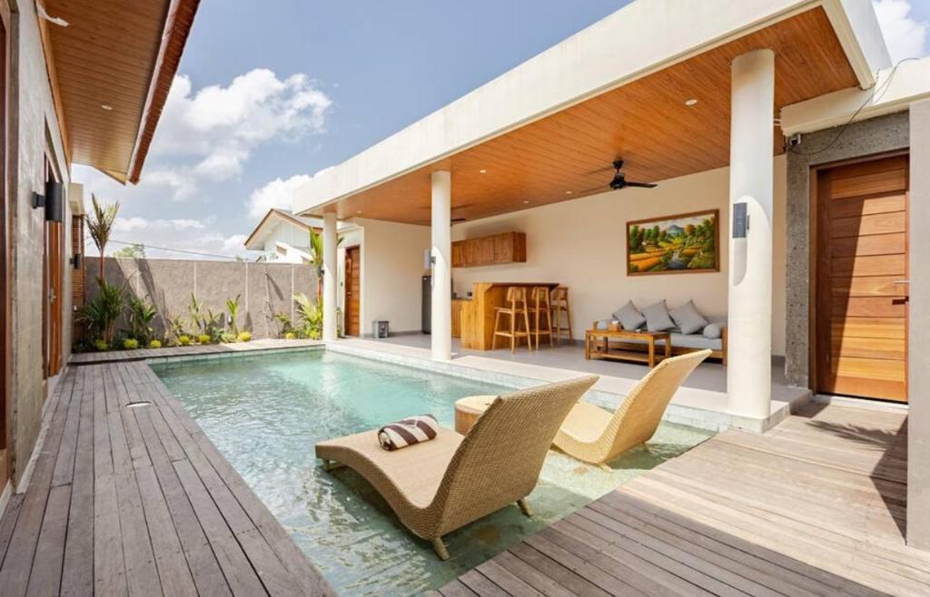 een villa met een zwembad en een huis bij Okananda Villa Ubud in Ubud