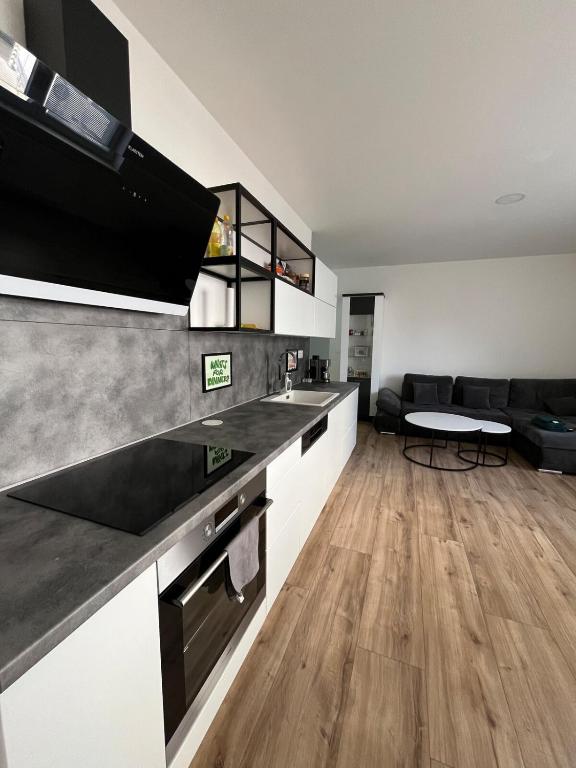 a kitchen with black and white counters and a table at Central and Spacious Apartment with All Amenities in Nitra