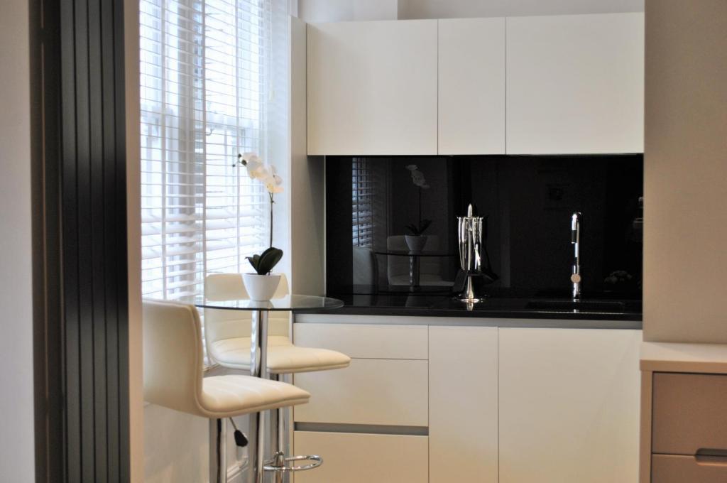 a kitchen with a table and a white counter top at Leicester Square One in London