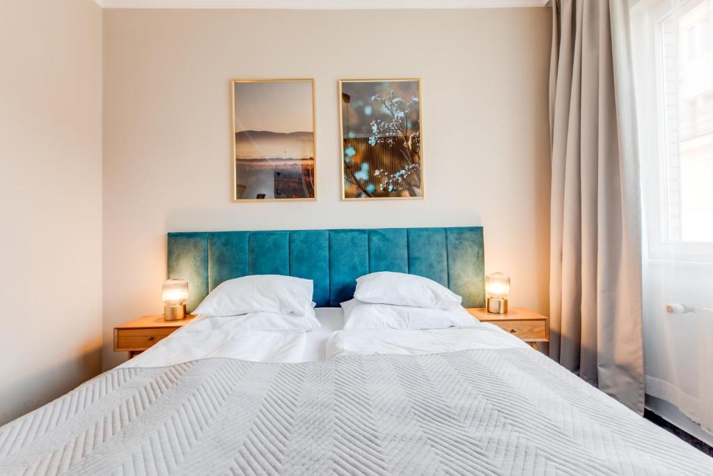 a bedroom with a large white bed with two lamps at Hotel Andante in Prague