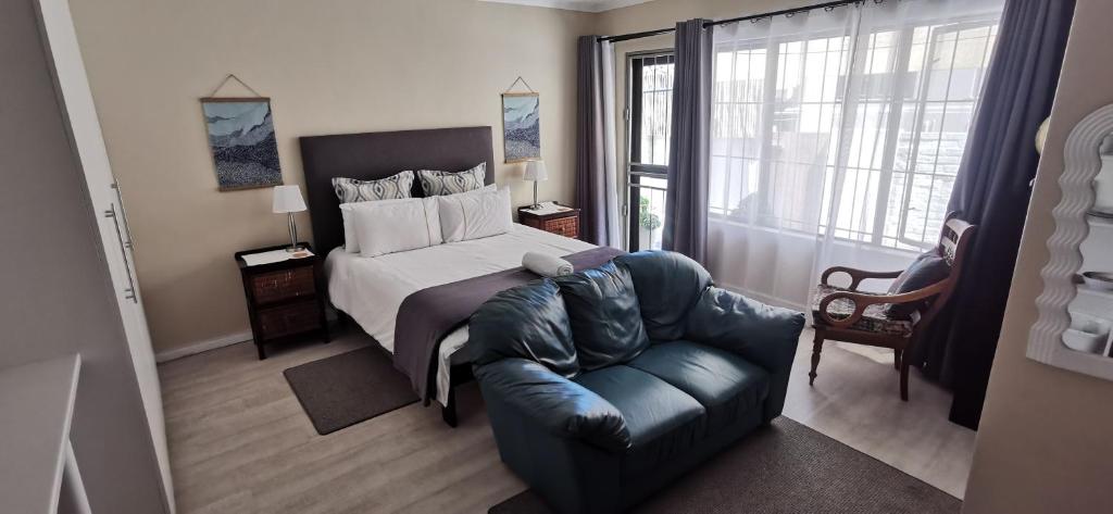 a bedroom with a bed and a couch and a chair at Mila's at Panorama in Panorama