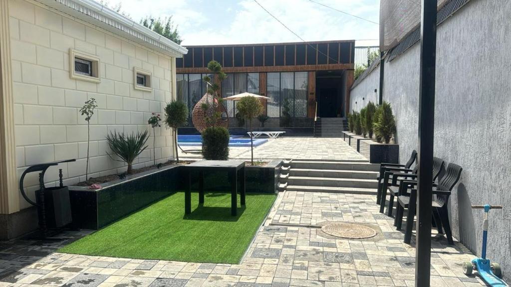 a courtyard with a lawn in front of a building at Гостевой дом in Shymkent