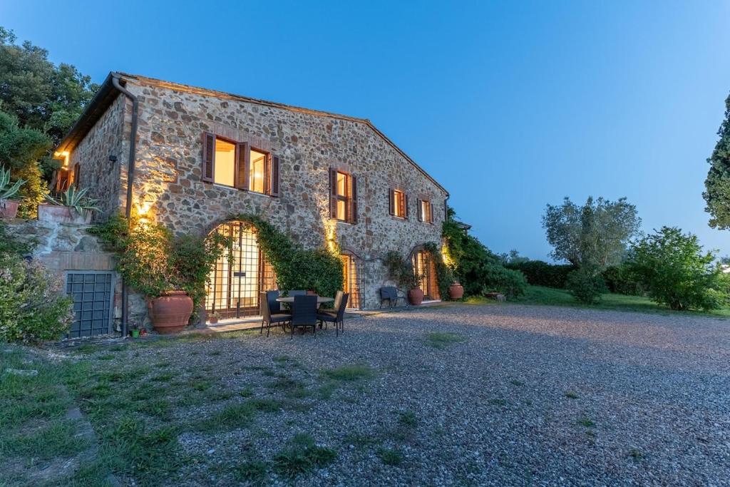 a large stone building with lights on it at Pieve Vecchia, Luxury Tuscan Retreat with Spa in Campagnatico
