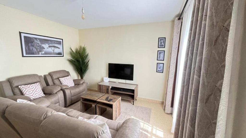 a living room with a couch and a tv at Frost Haven in Eldoret