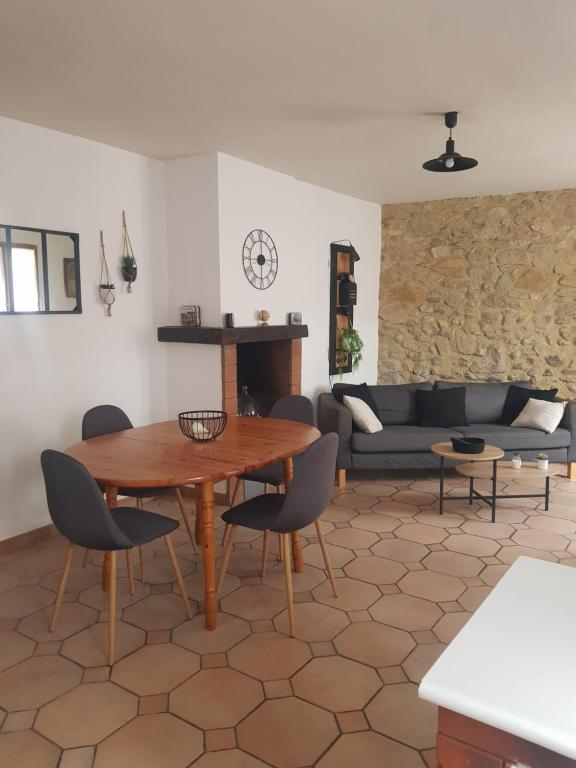 a living room with a wooden table and chairs at Maison dans un village calme in Carla-de-Roquefort