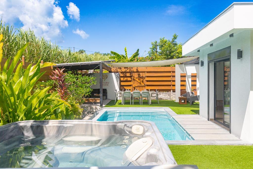 a swimming pool in the yard of a house at Domaine Simini - Villas et Chalet entre mer et montagne in Sainte-Rose