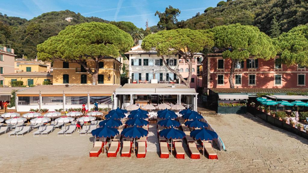 een groep stoelen met parasols en tafels bij Eight Hotel Paraggi in Santa Margherita Ligure