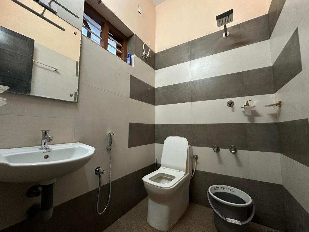 a bathroom with a toilet and a sink at SeaCret by Dormer Stay in Kozhikode