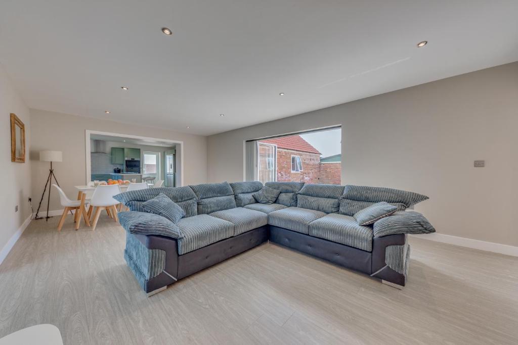 a living room with a blue couch and a table at Luxury Cottage, Dog Friendly, Stunning Views, Private Garden in Lincolnshire