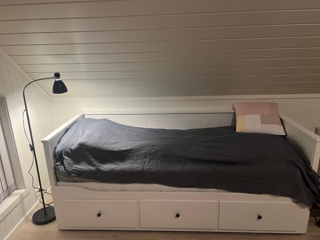 a bed with a black comforter in a bedroom at Lofoten - Spacious Room in Vestvågøya