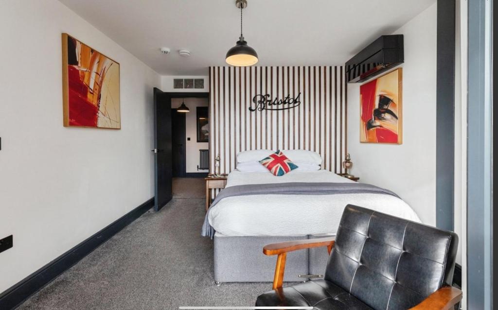 a bedroom with a bed and a chair at Duplex Apartment Harbourside city centre in Bristol