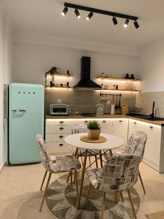 een keuken met een tafel en stoelen en een koelkast bij Simple Home in Kardítsa