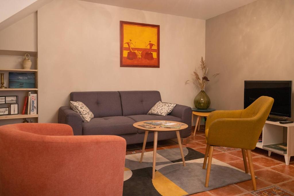 ein Wohnzimmer mit Couch und Stühlen in der Unterkunft La Maisonnette Etape de Saint-Côme d'Olt in Saint-Côme-dʼOlt