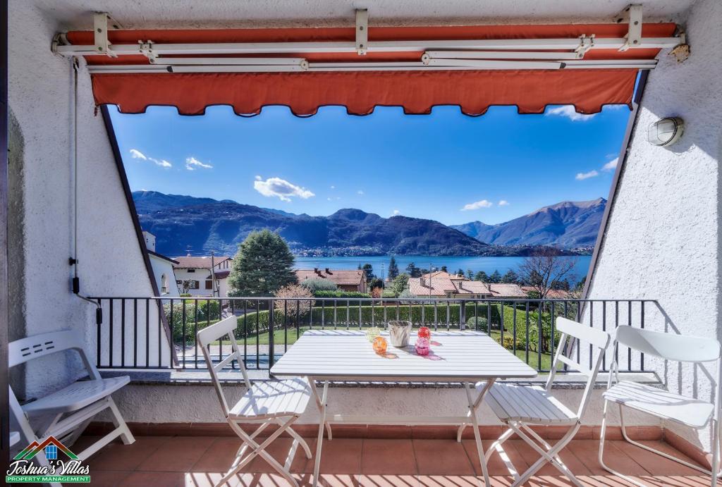 a table on a balcony with a view of a lake at Claudias Flat with Lake View and Pool in Lierna