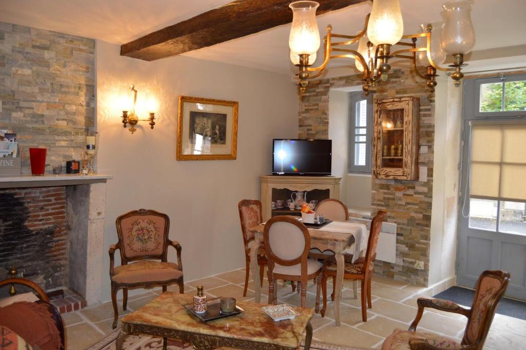 een woonkamer met een tafel en een open haard bij Haut du Blanc in Le Blanc