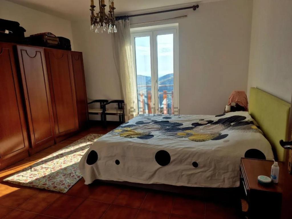 een slaapkamer met een bed met een groot raam bij Casa Mare & Monti in Caprauna