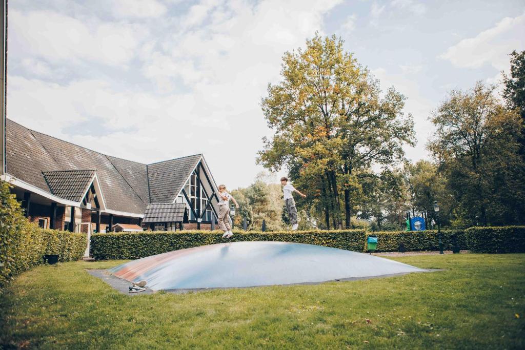 two people are standing on top of a trampoline at Vennenhof Wellness Bungalow | 6 personen in Hooghalen