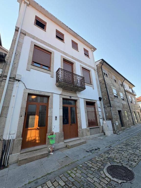a person standing in front of a building at Casa Do Sino II in Arcos de Valdevez
