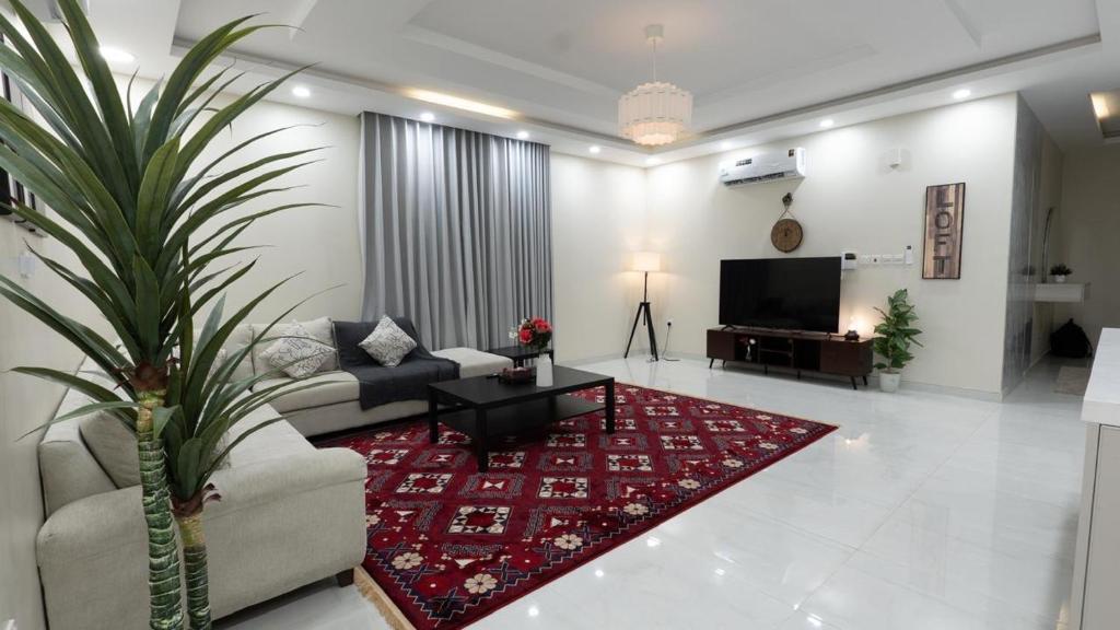 a living room with a couch and a red rug at Cozy Escape in Dammam