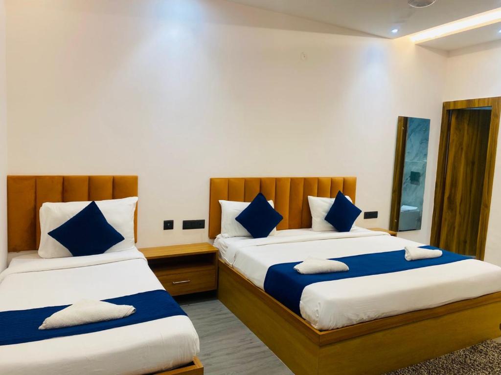 a bedroom with two beds with blue and white pillows at Hotel Taj Way by Jyoti Villa in Agra