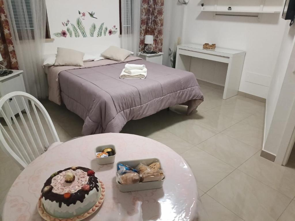een kamer met een bed en een tafel met een taart erop bij Fiera di Roma B&B in Ponte Galeria