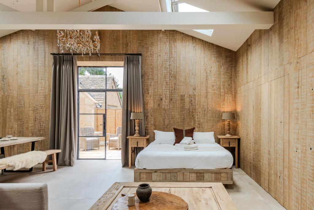 a bedroom with a bed and a table at Luxury Cotswold Retreats in Moreton in Marsh