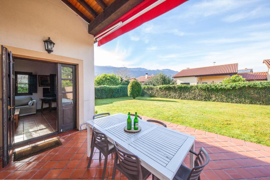 a table and chairs on a patio with a yard at Your retreat on the Asturian coast in Andrín