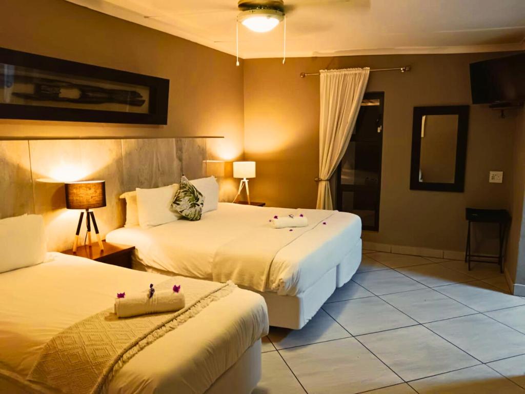 a hotel room with two beds with candles on them at The Wilds Guest House in Hluhluwe