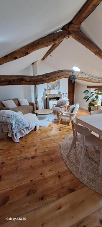 a living room with a bed and a table at Le Grenier des Moineaux Chezchristineetfabrice in Odeillo-Via