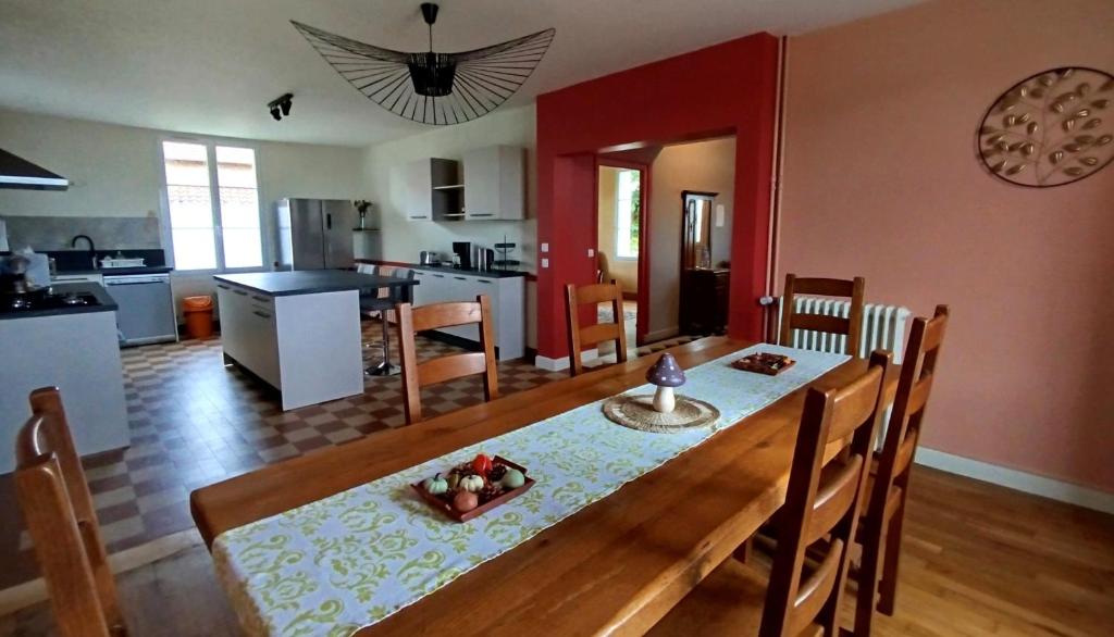AntignyにあるMa Pause Champêtreのテーブルと椅子のあるダイニングルームとキッチン