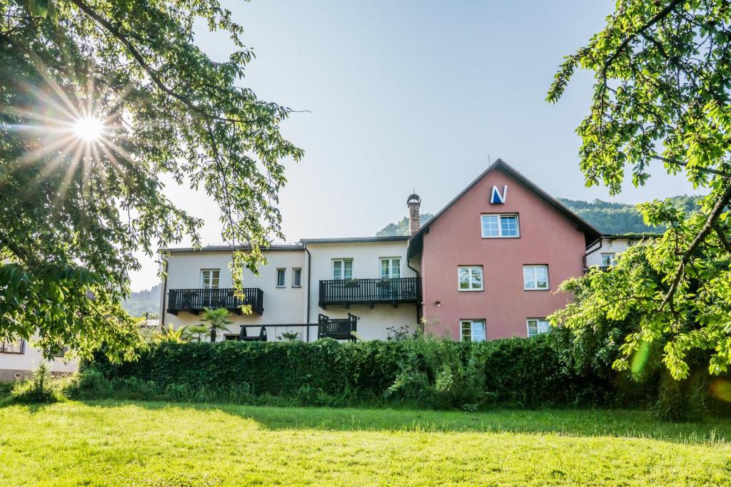 a house in the middle of a grassy field at Penzion Neco in Malá Skála
