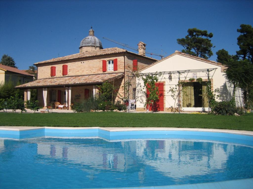 una casa con una piscina di fronte di B&B Belcuore a Macerata