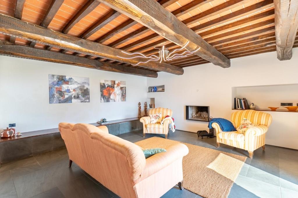 a living room with couches and a fireplace at La Fornace - Charm and modern villa in Tuscany in Campagnatico