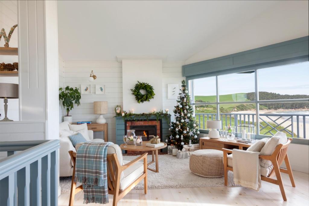 a living room with a christmas tree and a fireplace at Wishome-Casa de cuento en playa de Oyambre, Comillas in San Vicente de la Barquera