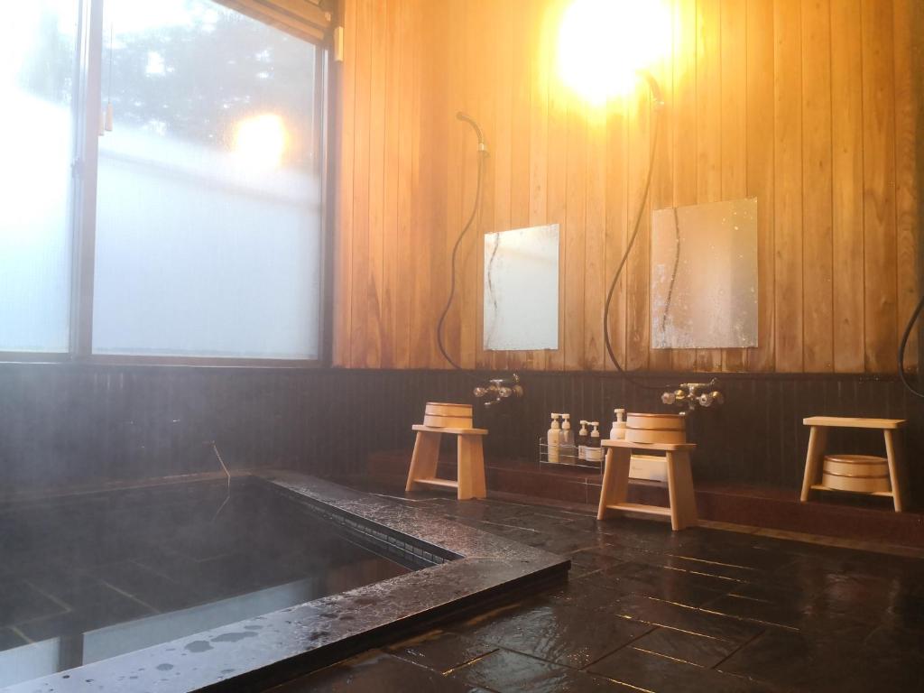 霧島市にある～みらい荘～　天然温泉付き一日一組様限定の６４坪広々民泊別荘の木製のスツール2脚と窓のあるバスルーム