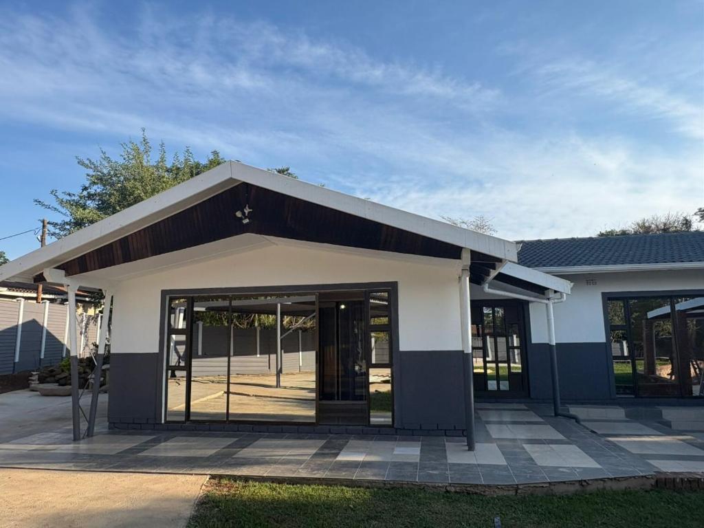a building with glass doors on the side of it at Mitchell Guest House Golf Road in Pietermaritzburg