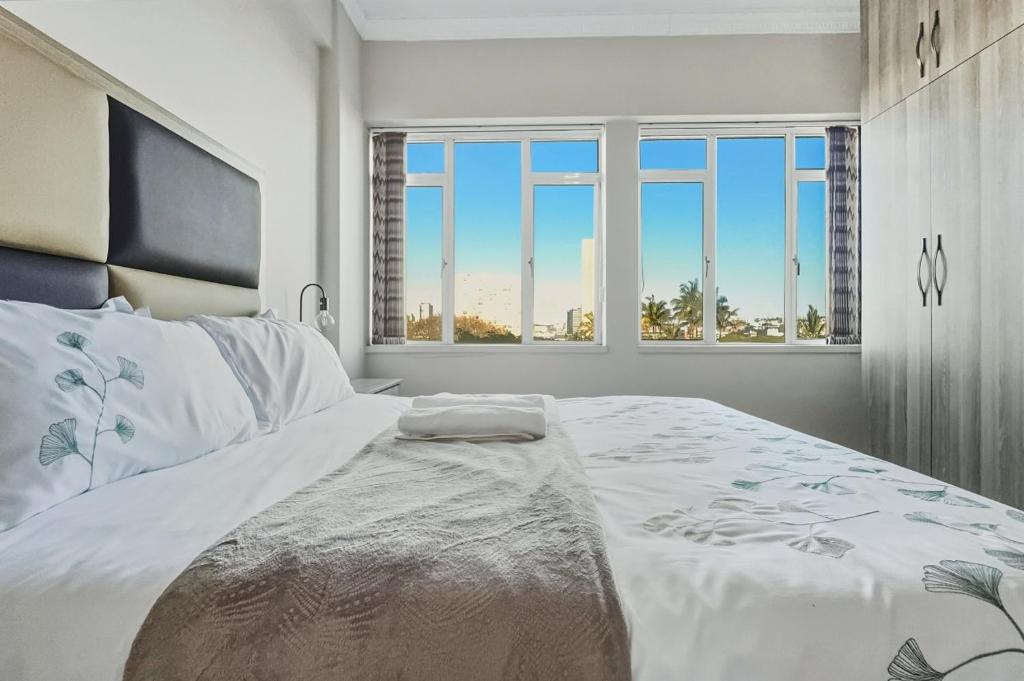 ein Schlafzimmer mit einem großen weißen Bett mit einem Fenster in der Unterkunft Beach Hurst 303 in Durban
