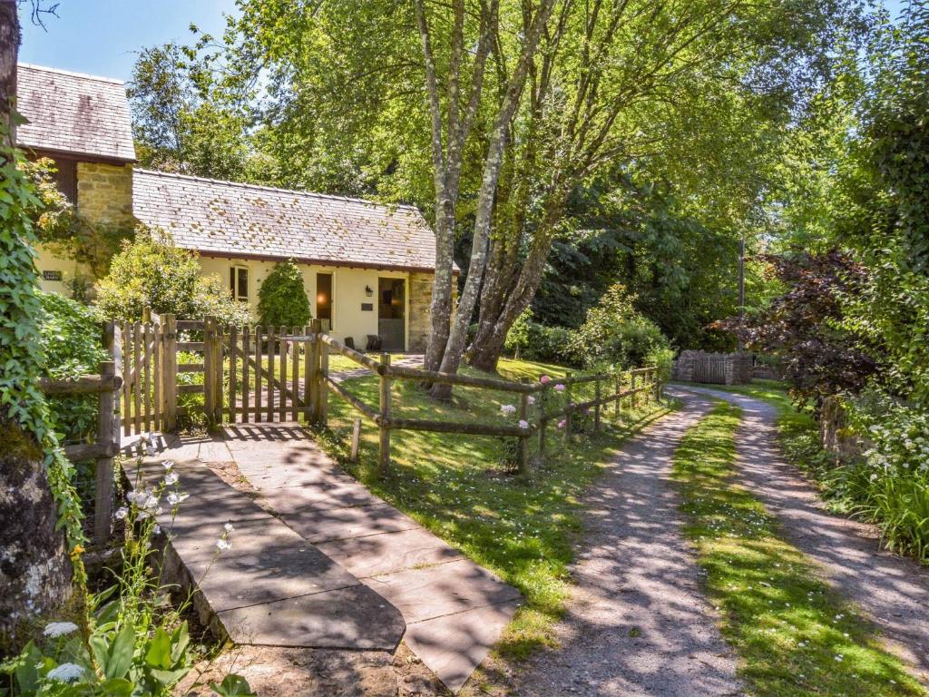 a country house with a wooden fence and a driveway at 1 Bed in Netherbury DC021 in Netherbury
