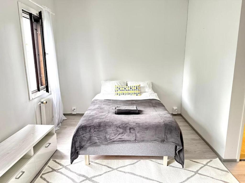 ein Schlafzimmer mit einem Bett in einem weißen Raum in der Unterkunft RD Apartments - Viinikan Ruusu in Tampere