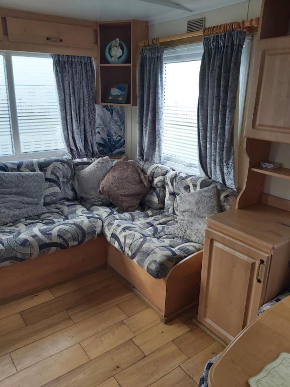 ein Sofa in der Mitte eines Zimmers mit Fenstern in der Unterkunft The Chase Caravan Park Ingoldmells ref EE in Skegness