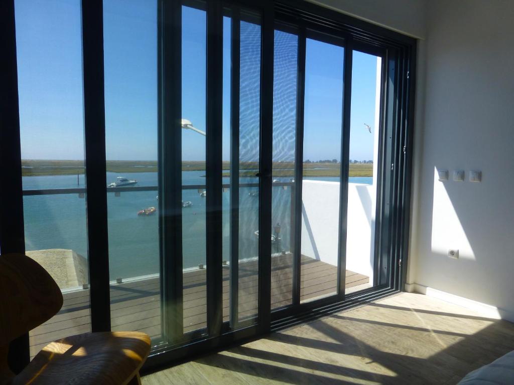 a room with a large window with a view of the water at Flamingo Beach House in Santa Luzia