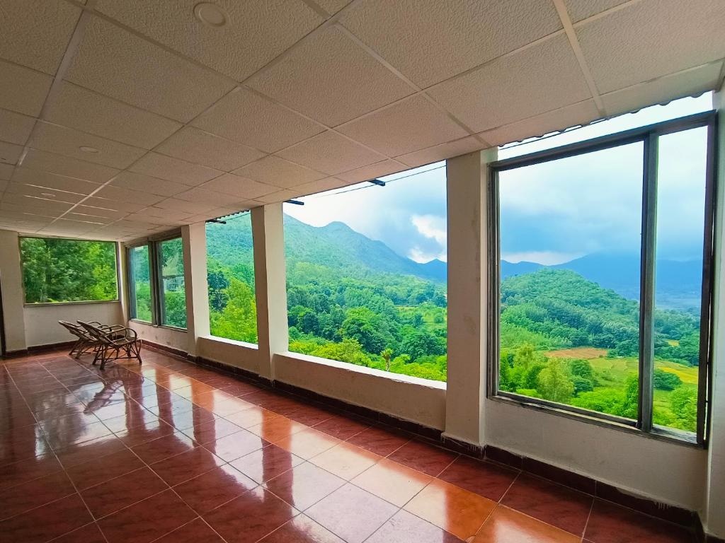 an empty room with a view of a mountain at Kings Court Village Resort in Araku