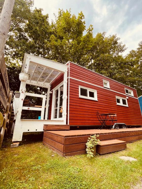 a red tiny house sitting on top of a yard at Tiny House Ruhr im PIER9 Tiny House Hotel in Hamm