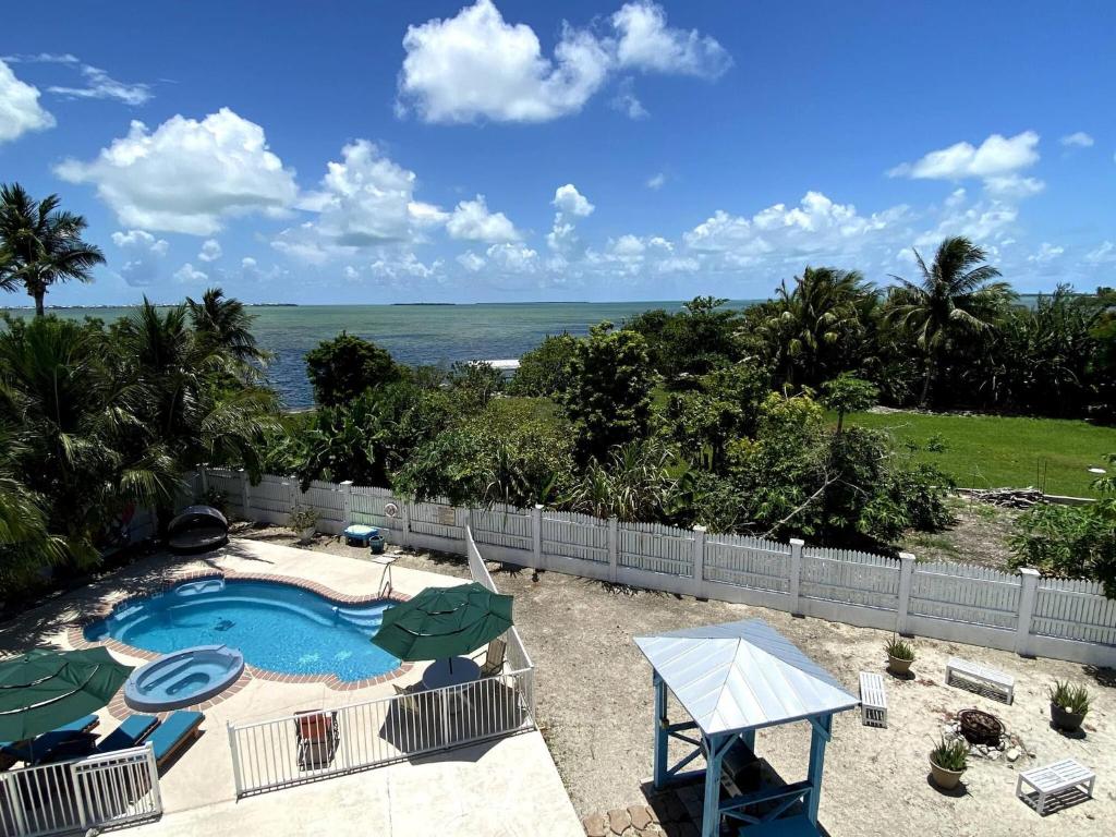 una imagen de una piscina con sombrillas y el océano en Eco Friendly Secluded OceanView Pool near Key West, en Cudjoe Key