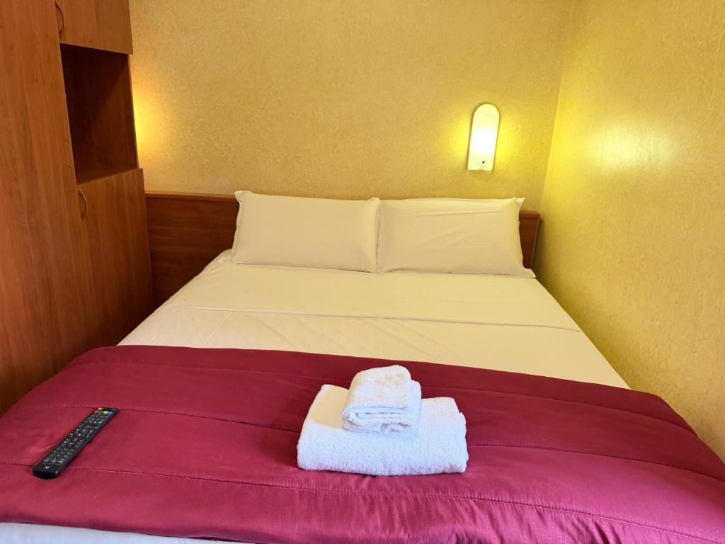 ein Bett mit zwei Handtüchern und einer Fernbedienung darauf in der Unterkunft Hotel Bruna in Rom