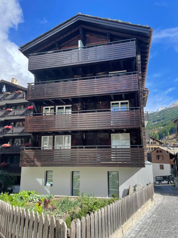 um edifício com uma cerca na frente em Haus Rosa em Zermatt