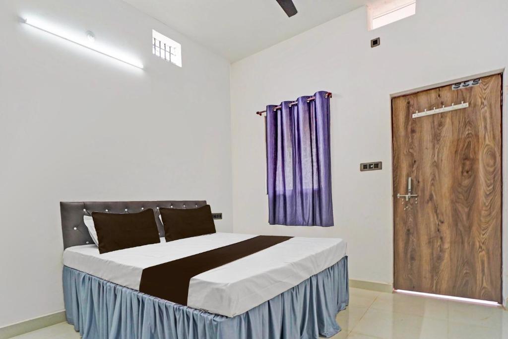 een slaapkamer met een bed en een houten deur bij Hotel O Dream Star in Bhilai