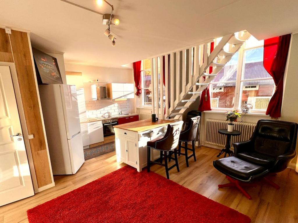 a kitchen with a staircase and a red rug at Centrally-located Unique Private apartment with 3 floors in Smedjebacken